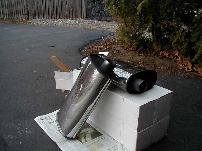 Chrome exhaust tip on cardboard boxes, newspaper underneath