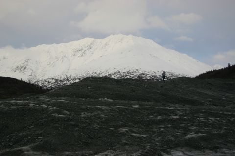 2003 Jeep TJ - A person surveys a vast, snow-capped mountain range under a cloudy sky.