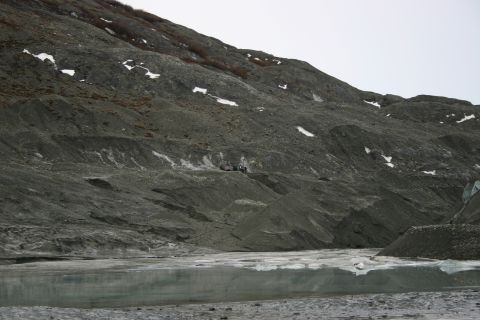 2003 Jeep TJ - A group of people are gathered on a barren, rocky mountainside near a glacial area.