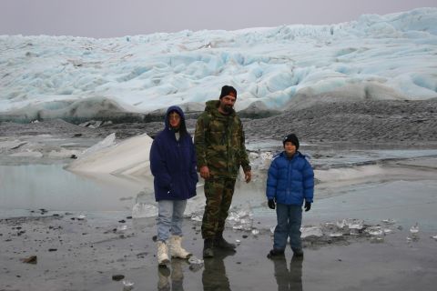 2003 Jeep TJ - A family poses for a photo in front of a large glacier on a cold, overcast day.
