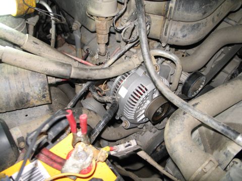 1995 Ford Bronco - Close-up view of engine bay components, including an alternator and battery terminals.