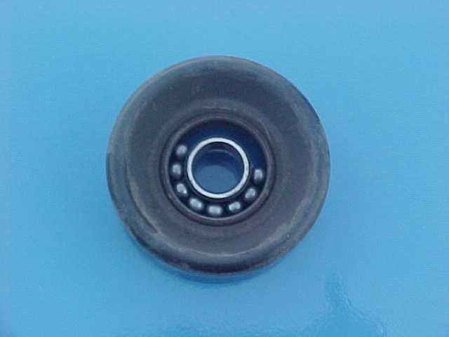 Idler pulley with visible ball bearing, set against a blue background