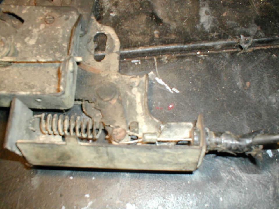 Door latch mechanism with spring and cable