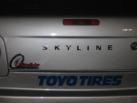 1986 Ford Bronco - The rear of a silver car displays SKYLINE badging and a TOYO TIRES sticker.