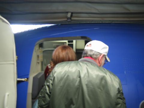 1968 Ford Mustang - People are seen boarding an aircraft through an open door.