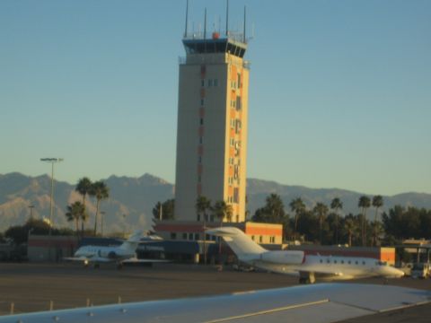1968 Ford Mustang - Airport scene with control tower and parked jets under a clear sky.