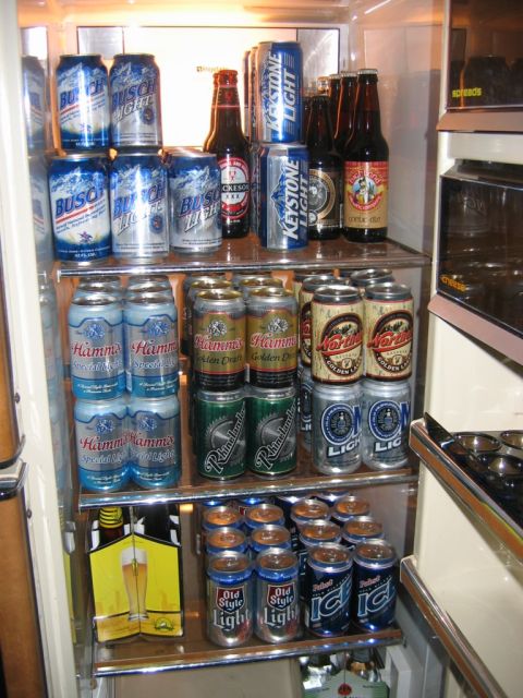 1985 Ford LTD Crown Victoria - A full refrigerator stocked with a variety of beer brands, including Busch, Keystone Light, Hamm's, and Old Style.