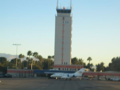 1968 Ford Mustang - An airport control tower stands tall against a clear sky, with a private jet parked on the tarmac below.