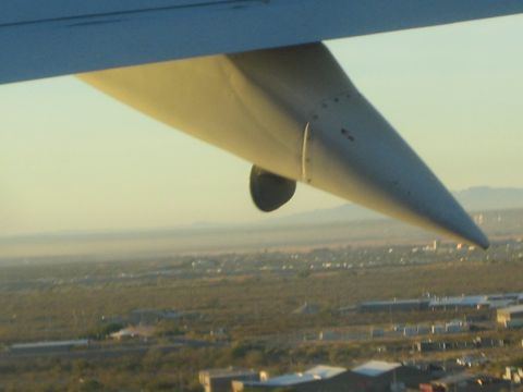 1968 Ford Mustang - View from an airplane window shows the wingtip extending over a distant, hazy landscape.