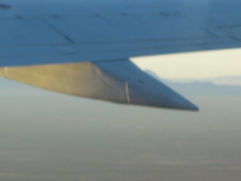 1968 Ford Mustang - Airplane wingtip visible against a hazy sky and distant mountains.