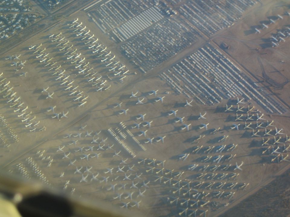 Aerial view of many parked airplanes in a desert boneyard