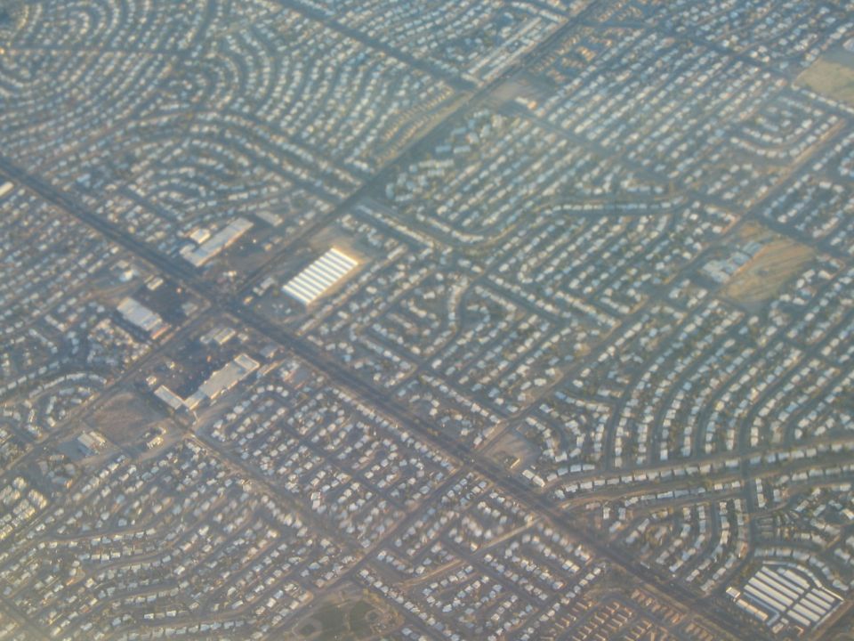 Aerial view of curving streets and dense housing in a suburban neighborhood