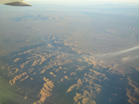 1968 Ford Mustang - An aerial perspective captures the vastness of desert terrain and mountain ranges under a hazy sky.