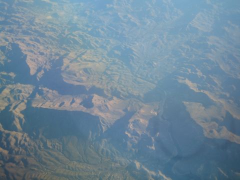 1968 Ford Mustang - An aerial perspective reveals the vastness of mountainous landscapes under a hazy sky.