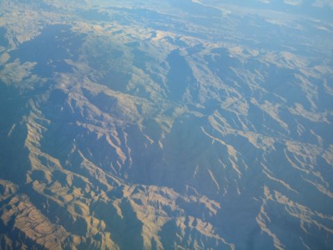 1968 Ford Mustang - An aerial perspective captures the dramatic topography of a mountain range, with shadows defining the contours of the landscape.