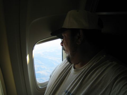 1968 Ford Mustang - A passenger gazes out the window of an airplane at the landscape below.
