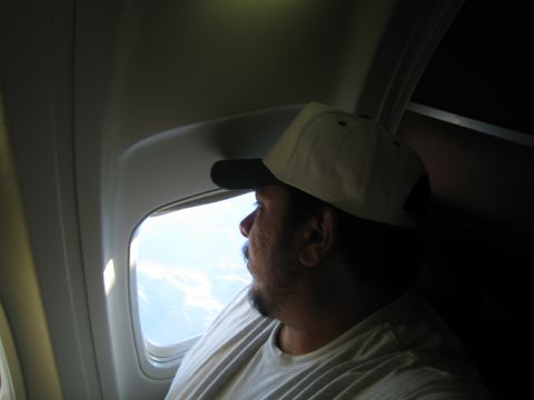 1968 Ford Mustang - Passenger gazes out the window during a flight, observing the view from above.