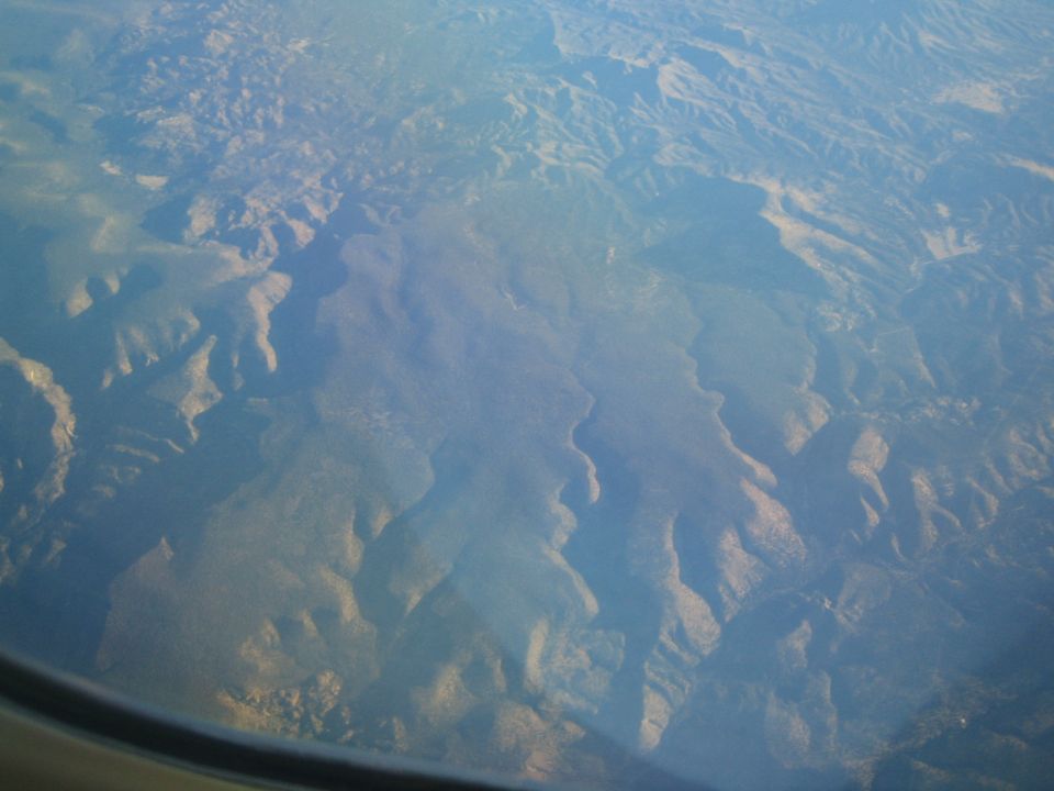 Aerial view of mountains and valleys from an airplane window