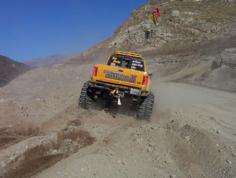2000 Ford F-450 - Straight-on rear view of a yellow lifted extended-cab pickup with "Tonka III" tailgate lettering, a rear-mounted winch and tube bumper, and…
