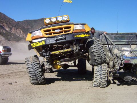 2000 Ford F-450 - Modified yellow Ford pickup truck with oversized tires and 'Tonka III' branding is shown off-road.