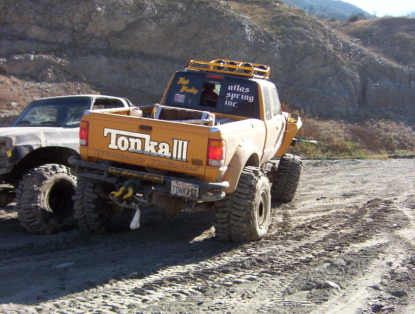 Rear of yellow Tonka III off-road pickup with tube bumper on a trail