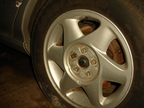 1992 Ford Taurus - Close-up of a car's wheel and tire, showing the silver 5-spoke rim and brake components.