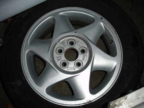 1992 Ford Taurus - This silver 5-spoke wheel with tire is from a 1992 Ford Taurus.