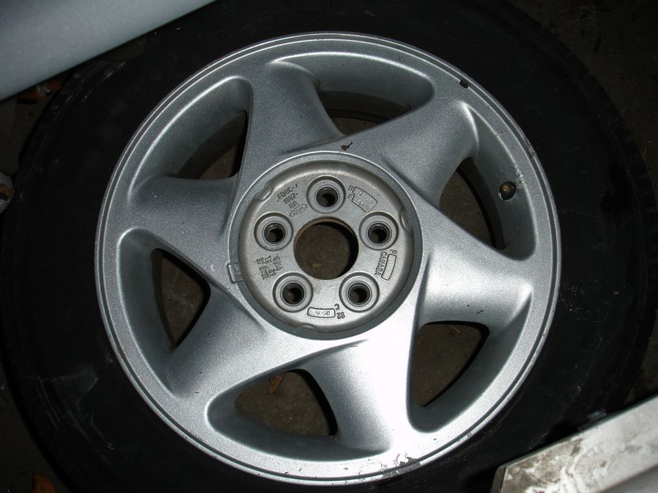 Silver 5-spoke wheel with tire, 1992 Ford Taurus