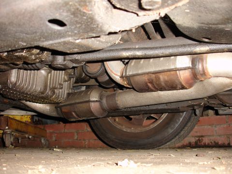 1992 Ford Taurus - Underside view of a vehicle's exhaust system and transmission components, showing the catalytic converter.