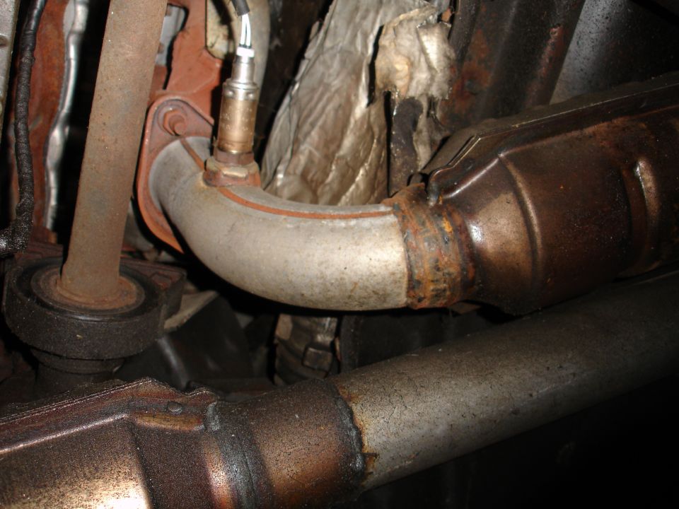 Close-up of exhaust pipe, catalytic converter, and oxygen sensor