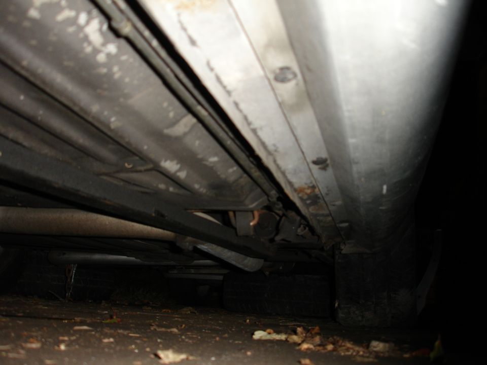 Underbody view of a car showing subframe connectors and exhaust
