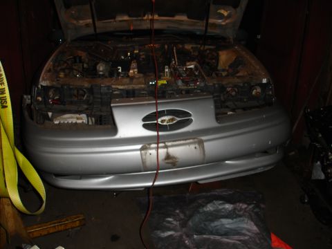 1992 Ford Taurus - The front of a car is shown with the hood up, revealing the engine compartment.