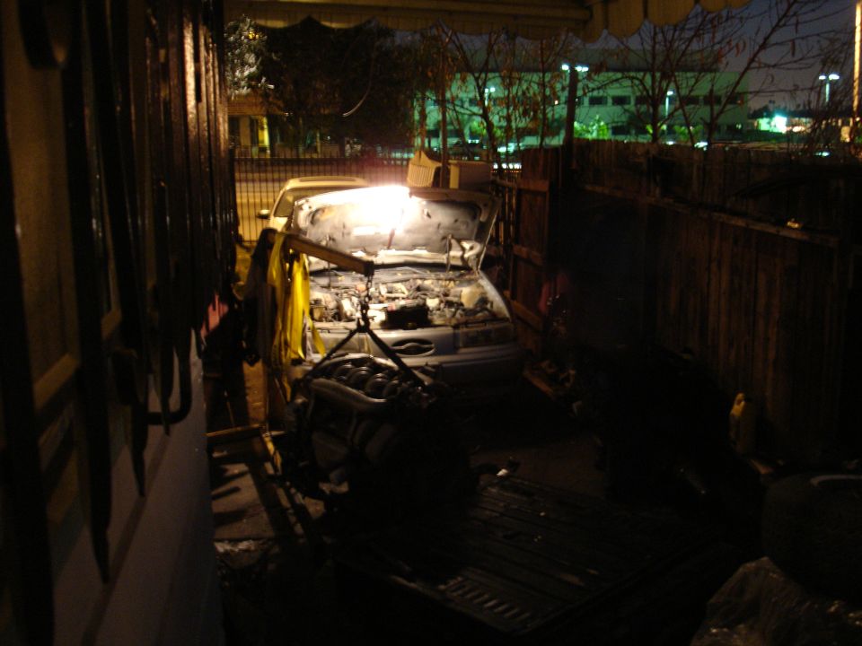engine hoist lifting engine out of car with hood open