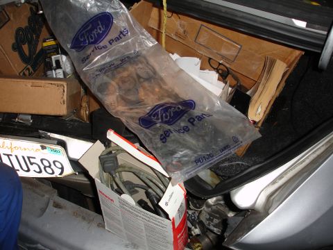 1992 Ford Taurus - A collection of items, including Ford service parts and boxes, are stored in the trunk of a vehicle.