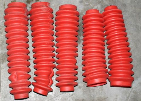 2003 Jeep TJ - A group of five red rubber bellows are displayed on a gray surface.