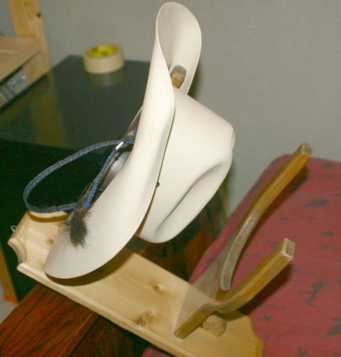 2003 Jeep TJ - A cowboy hat is mounted on a wooden display stand indoors.