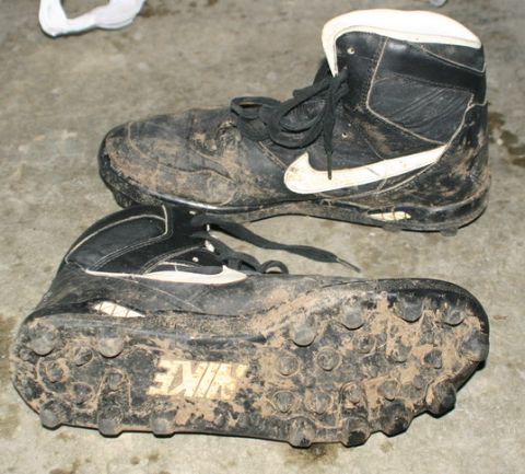 2003 Jeep TJ - A pair of dirty Nike cleats with visible tread and branding are shown resting on a concrete surface.