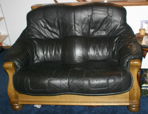 2003 Jeep TJ - A black leather sofa with wooden accents is shown in a room setting.