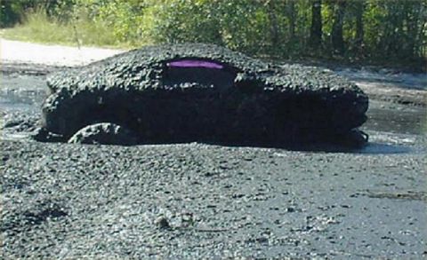 1987 Suzuki Samurai - This vehicle is deeply stuck in mud, with only a small purple section visible.