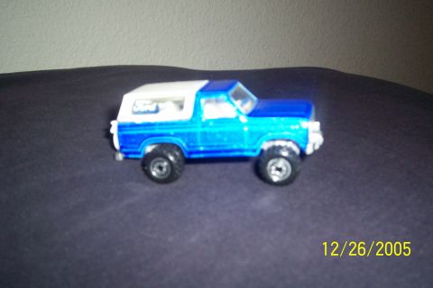 1995 Ford Bronco - A toy Ford Bronco is shown from a 3/4 front angle against a dark background.