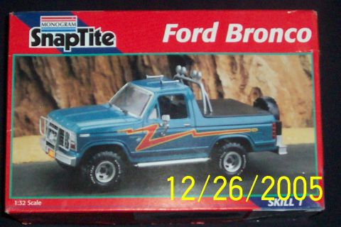1995 Ford Bronco - A Monogram SnapTite 1:32 scale Ford Bronco model kit box showing a blue lifted Bronco with red/orange lightning-bolt graphics, roll bar lig…
