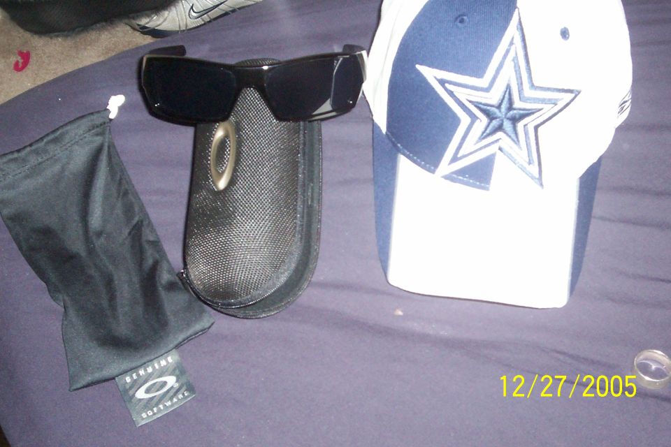 Oakley sunglasses in a case next to a Dallas Cowboys baseball cap