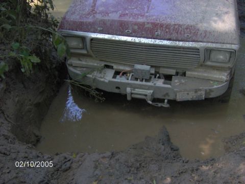 1978 Ford Bronco - This 1978 Ford Bronco is stuck in a muddy ditch, showing its front grille and winch.