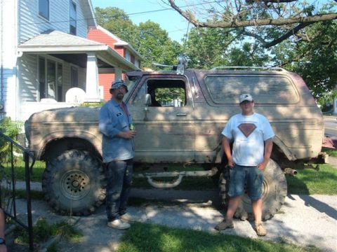 1978 Ford Bronco - Two men stand next to a heavily modified 1978 Ford Bronco with oversized tires.