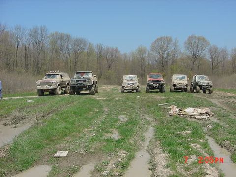 1978 Ford Bronco - A group of off-road vehicles are lined up on a muddy path, ready for an adventure.