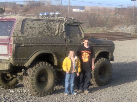 1978 Ford Bronco - This 1978 Ford Bronco is heavily covered in mud, with two children posing in front of it.