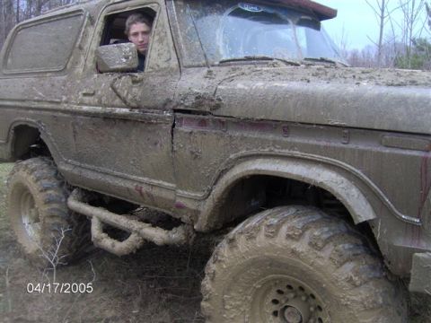 1978 Ford Bronco - This heavily muddied vehicle appears to be an older model SUV, possibly a Bronco, with significant off-road modifications.