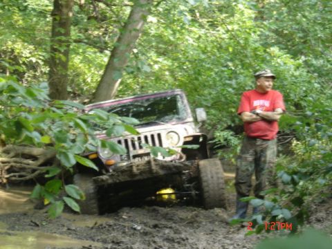 1978 Ford Bronco - Man watches as a Jeep Wrangler gets stuck deep in the mud during an off-road excursion.