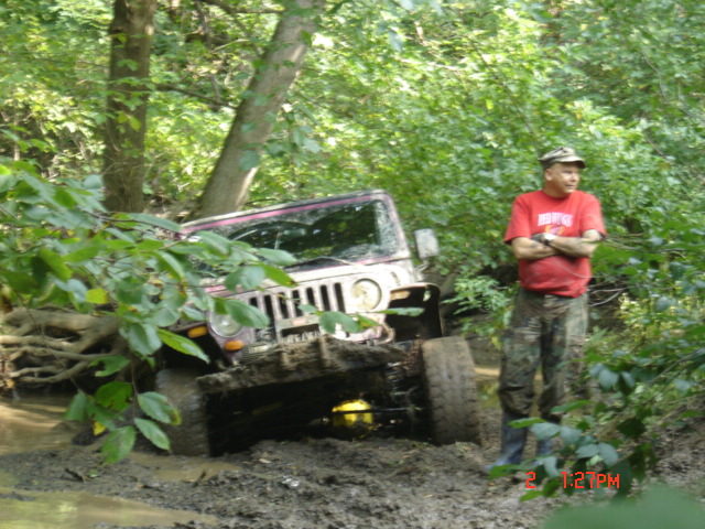 Jeep Wrangler stuck in mud, driver standing by. Mudding Buddies album