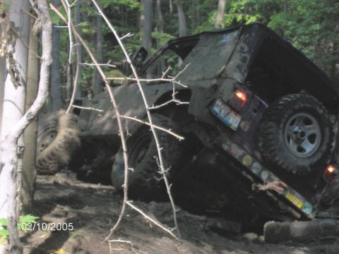 1978 Ford Bronco - Off-road vehicle stuck in mud on a forest trail, date stamp reads 02/10/2005.